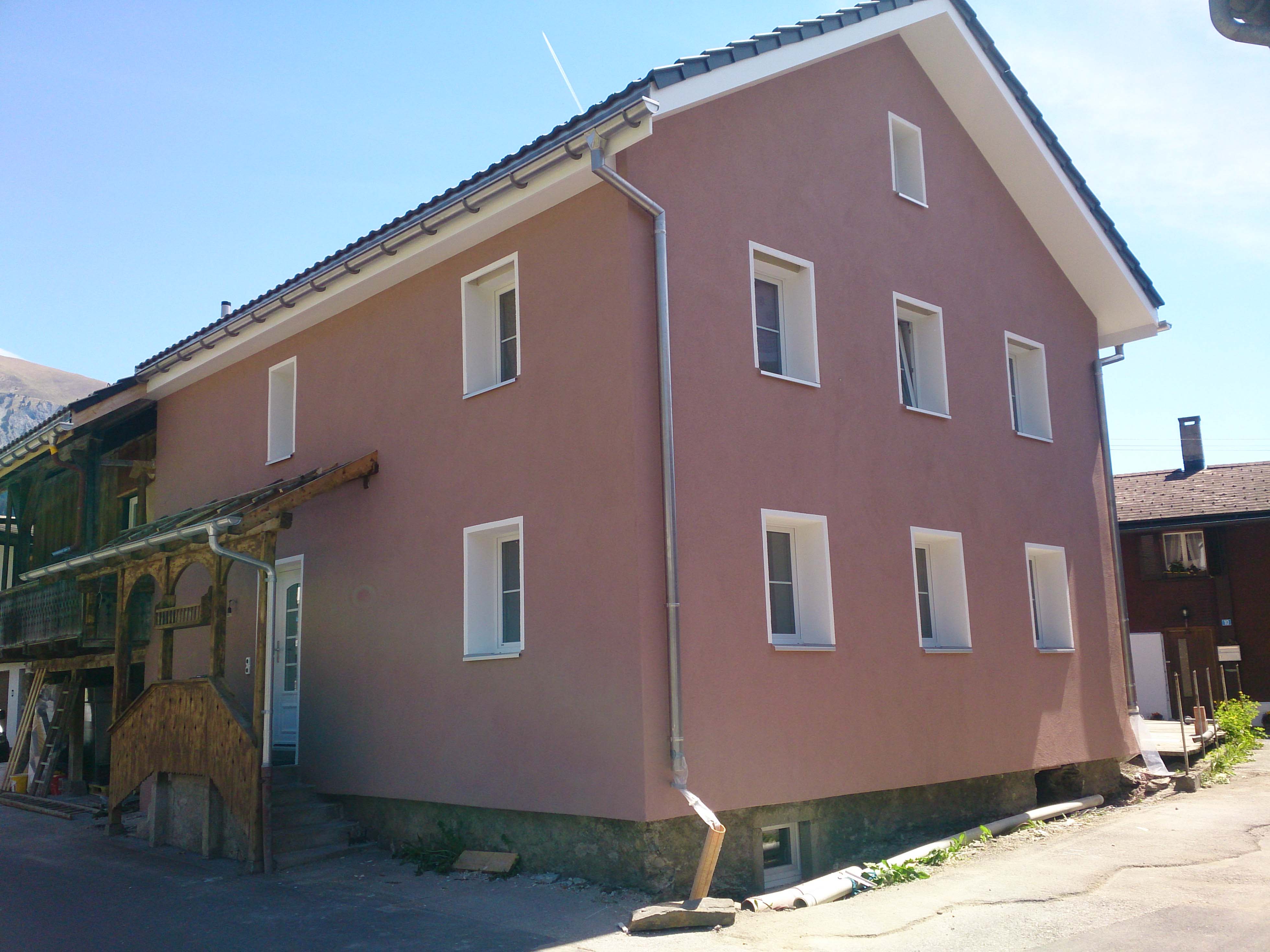 Rosa renovierte Hausfassade in einem Bündner Dorf